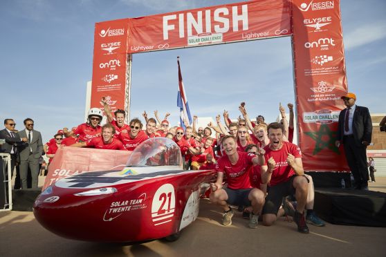 Teamfoto van een blij en juichend Solar Team Twente op de finish na de overwinning